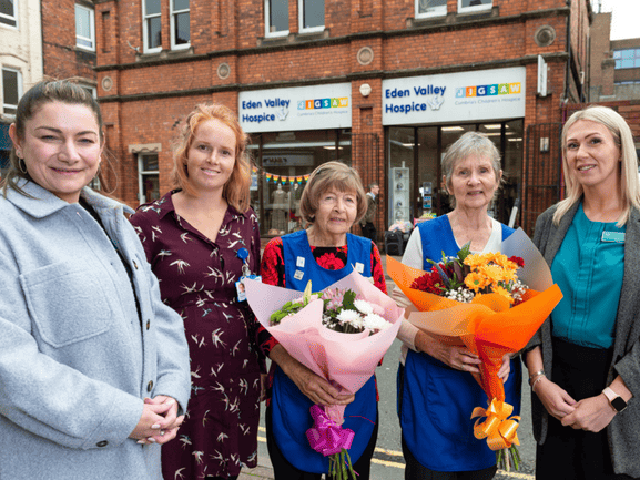 Volunteers and staff from Eden Valley Hospice and the Cumberland presenting a bouquet of flowers