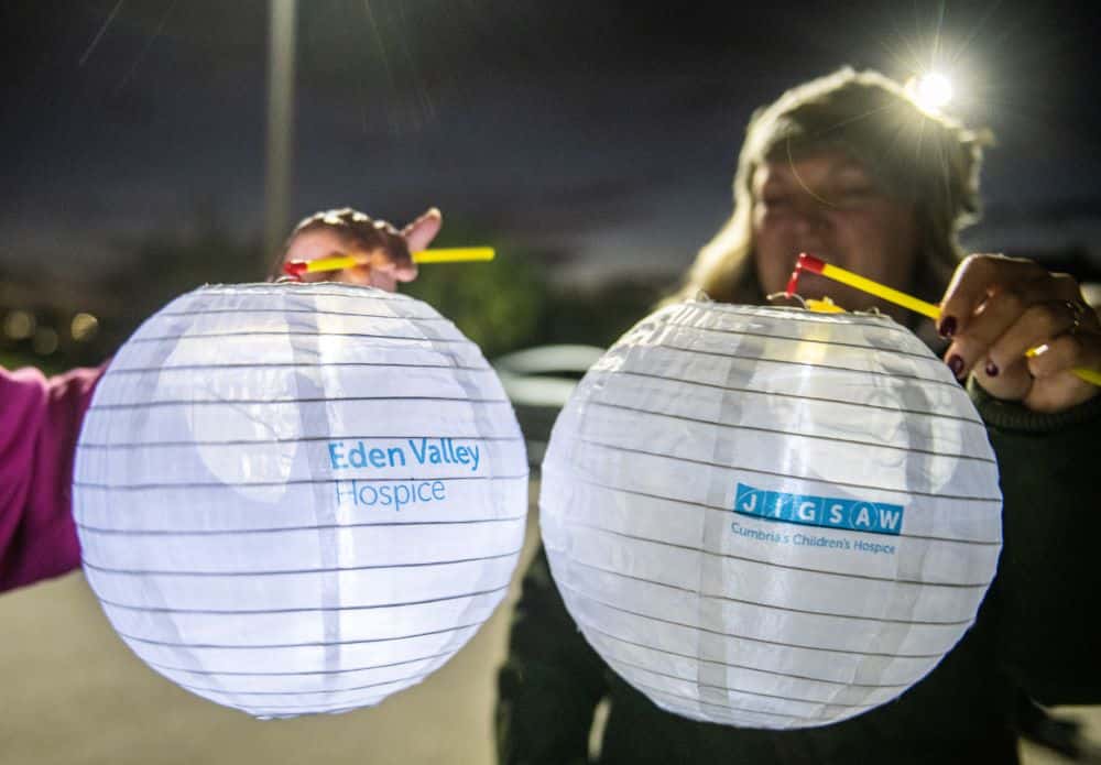 Woman holding up lanterns at the lantern walk fundraising event