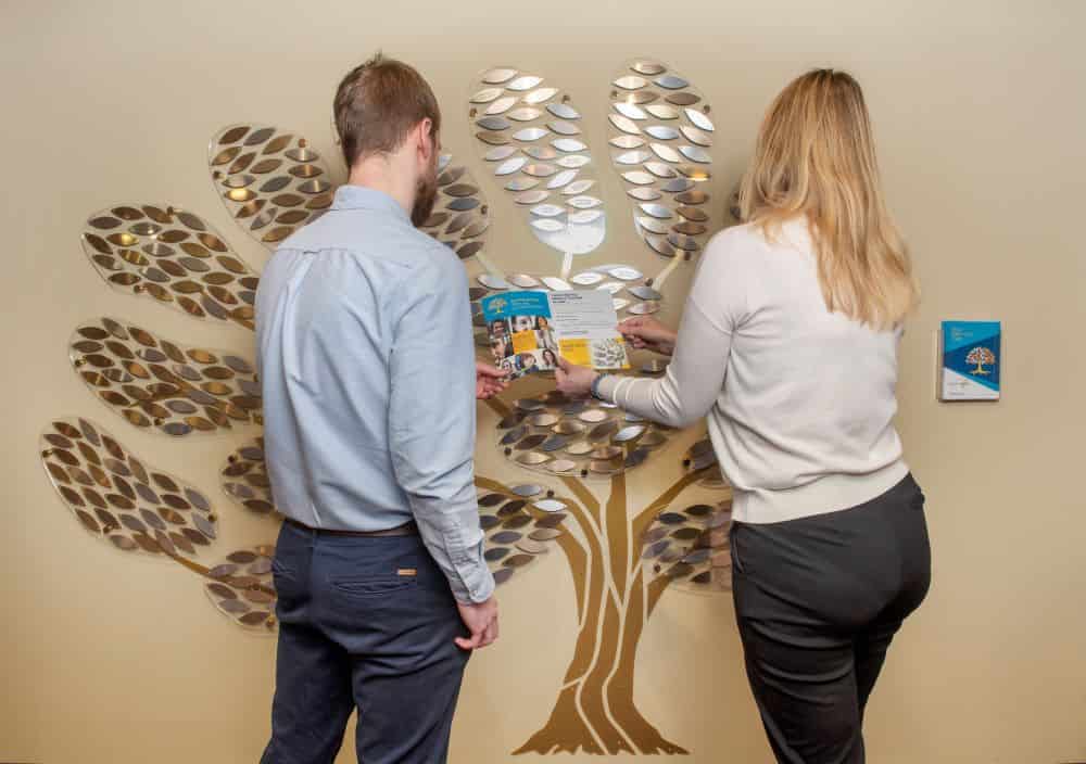 Two staff members looking at our memory tree