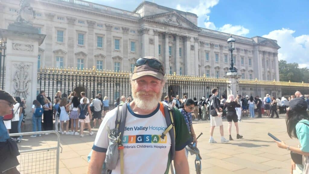 Adam Brown standing outside Buckingham Palace