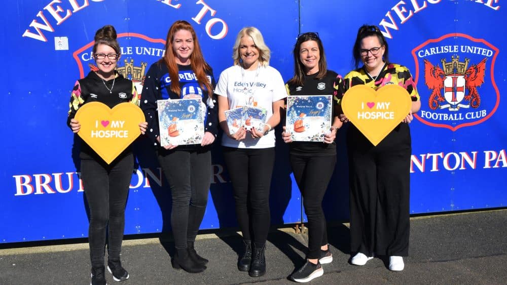 Members of Carlisle United store posing with Christmas cards.