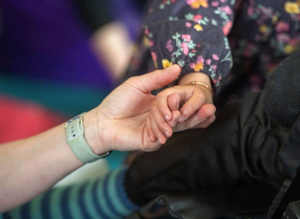 patient holding hands with care worker